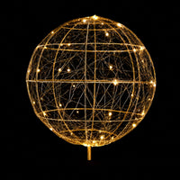 Fairybell gold topper ball with warm white lights in a wire frame against a black background